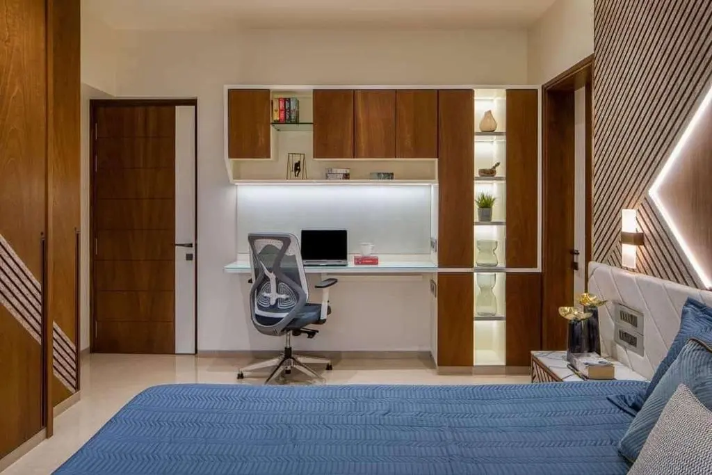 A bedroom with a bed, desk and a chair