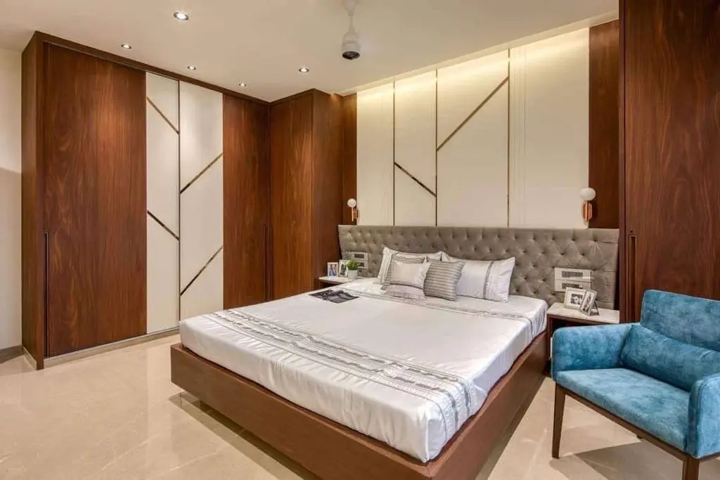 A bedroom with a large bed and a blue chair