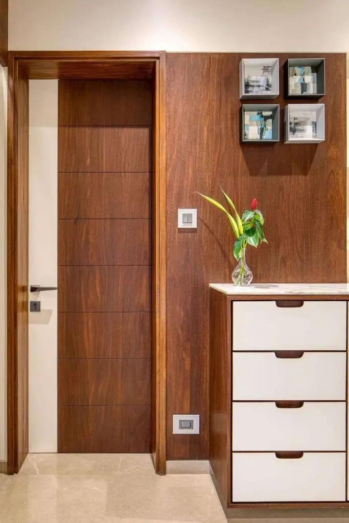 A room with a dresser and a vase with a flower in it